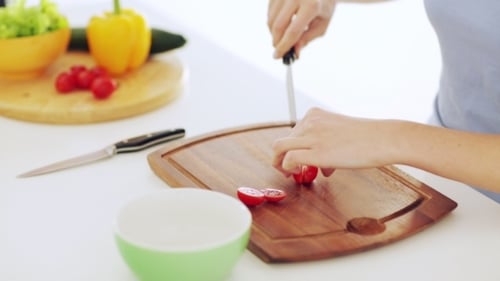 Woman Cutting Cherry Tomatoes on Cutting Board