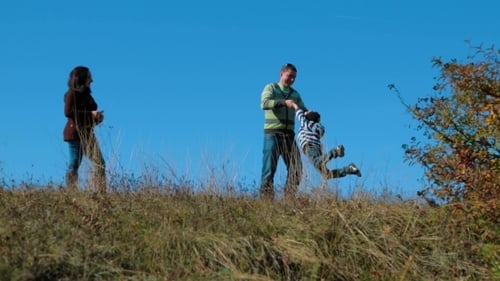Young Family Walking In Autumn Meadow