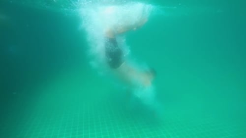 Man Dives Into a Swimming Pool Underwater