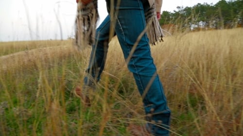 Woman Walks Dirt Path Through Golden Field