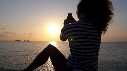 Woman Taking Photo of Beach Sunset