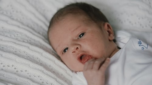 Sweet Infant Lying on a White Blanket