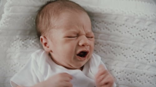 Close up of Crying Infant Lying on Blanket