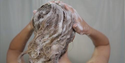 Woman Washing Her Hair with Shampoo in Shower