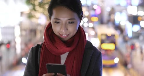 Woman use of mobile phone in city over traffic road background