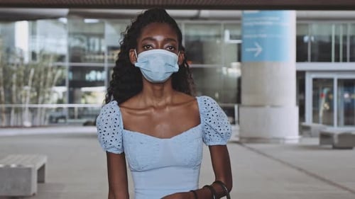 Linda mulher caminhando em direção à câmera enquanto puxava bagagem no aeroporto vazio