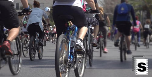 People Ride Bicycles on Urban Road