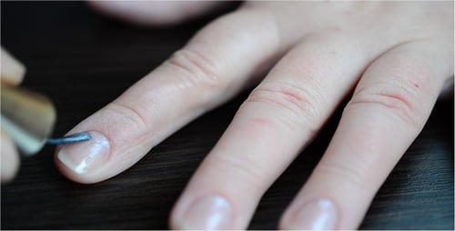 Woman Applies Nail Polish on Fingernails Close Up