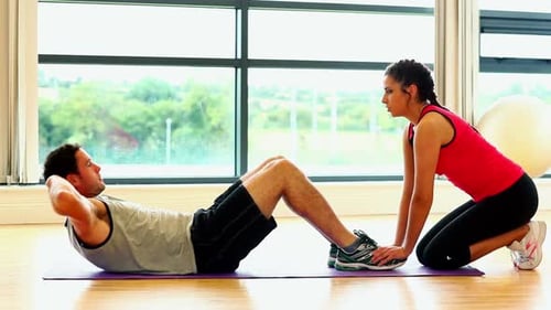 Homme en forme mignon faisant des situps dans la salle de fitness