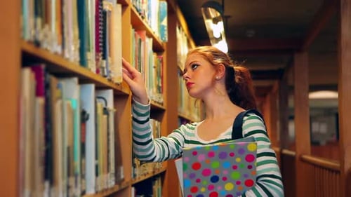 Étudiant ciblé choisissant un livre dans la bibliothèque