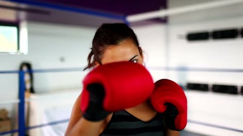 Woman Training, Punching with Red Boxing Gloves in Gym
