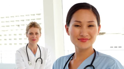 Smiling Surgeon With Doctor Behind Her