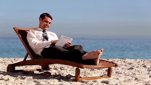 Barefoot Young Adult on Beach Using Tablet