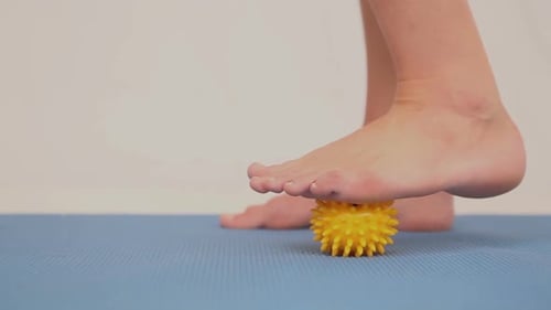 Foot Rolling on Yellow Massage Ball Close Up