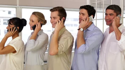 Businesspeople Phoning While Standing In A Row