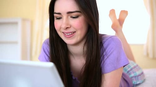 Young Woman Using Tablet in Bedroom