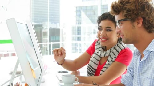 Jovens colegas trabalhando juntos no computador