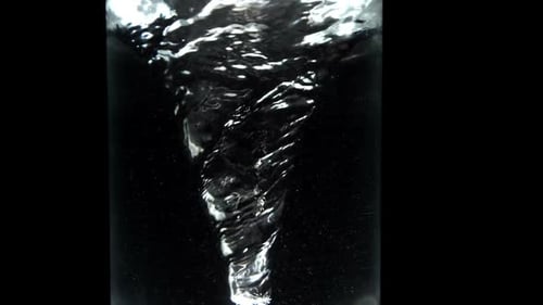 Whirlpool In Glass Of Water On Black Background Close Up