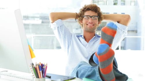 Young Man Relaxing in Office with Feet Up
