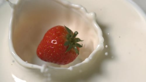 Fresa cayendo en la leche