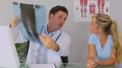 Doctor Reviews X-Ray with Patient in Office