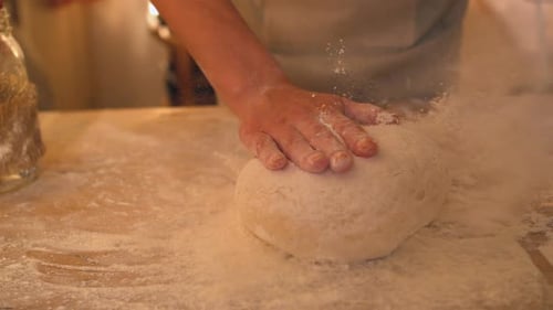 Baker Places Dough on Flour Covered Surface