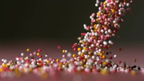 Viele Streusel fallen auf schwarze Oberfläche