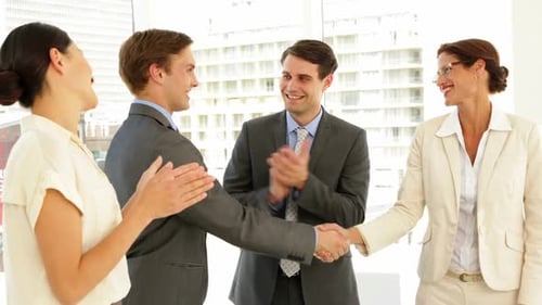 Colleagues Celebrate Success with Handshakes and Applause