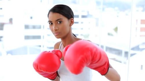 Woman in Boxing Gloves Punches Camera in Apartment