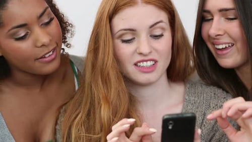 Three Cheerful Friends Looking at a Phone