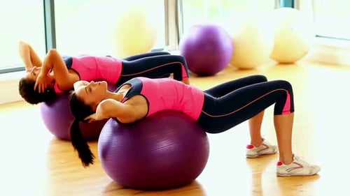 Women Doing Crunches on Exercise Balls in Gym