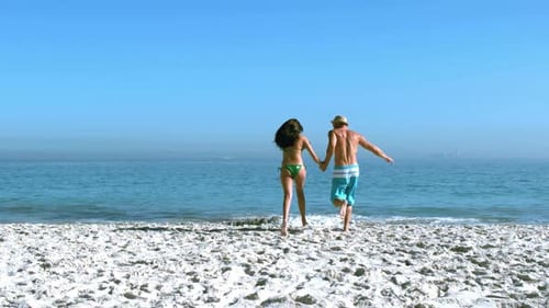 Handsome Man Running With His Friend Toward The Sea