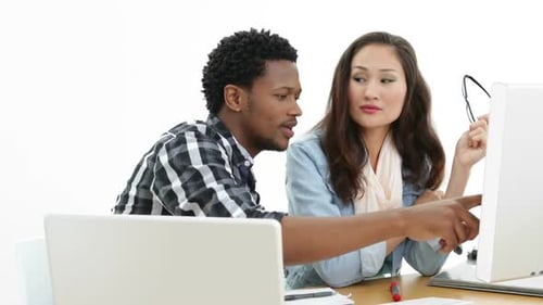 Equipe trabalhando na mesa usando laptop e computador
