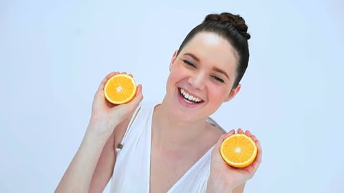 Young Adult Woman Smiles Holding Oranges