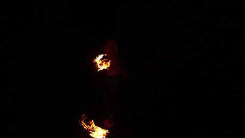 Performer Juggling Fiery Orbs at Night