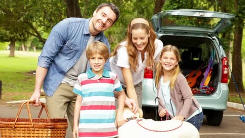 Parents Posing With Children And Pet Dog In The Park