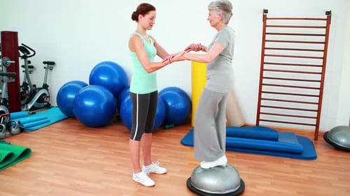 Senior Woman Doing Physical Therapy with Young Trainer