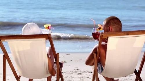 Couple Drinking Cocktail On The Beach