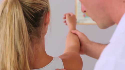 Doctor Examining Female Patient's Arm in Office