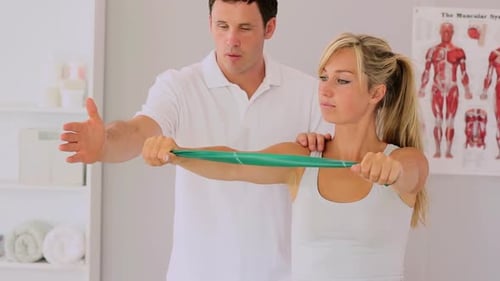 Woman Stretching Resistance Band with Physical Therapist