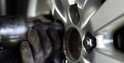 Mechanic Removing Lug Nuts With Power Drill Tool