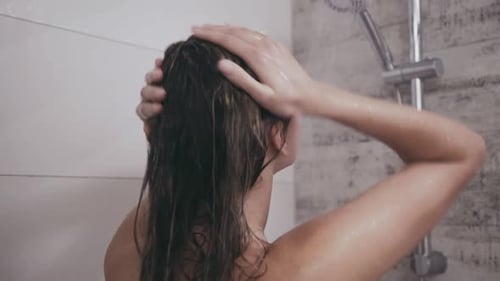 Woman with Wavy Hair Washing Shampoo in Shower