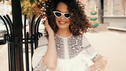 Smiling Woman With Curly Hair on City Street