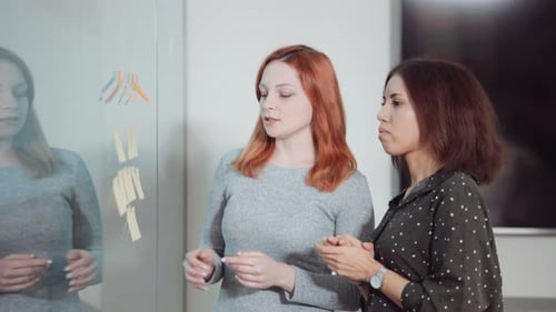Female Project Managers Monitoring Tasks on Agile Board