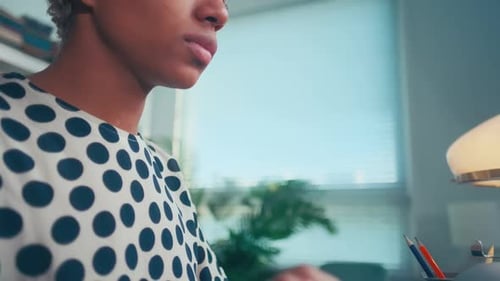Young African American Woman Secretary Typing on Old Typewriter Sits in Office