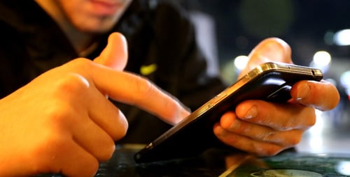 Person Using Smartphone at Night, Close Up