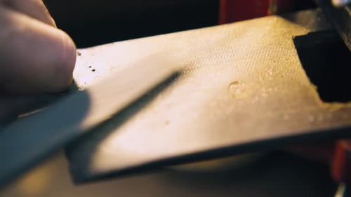 Juwelier poliert Goldstab und reinigt Nahaufnahme am Arbeitsplatz