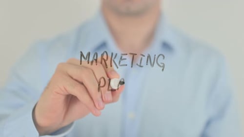 Hand Writing Marketing Plan on Clear Surface