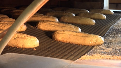 Bread Loaves Baking on Conveyor Belt in Oven