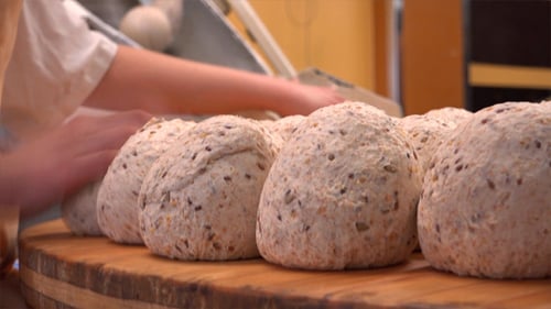 Baker Preparing Bread Dough Balls with Grains